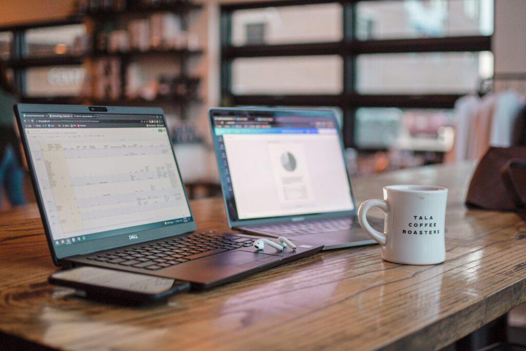A cafe table with two laptops and a mug